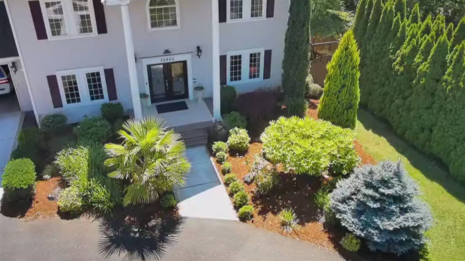 Front of a house with planted beds, bark dust and a clean walkway