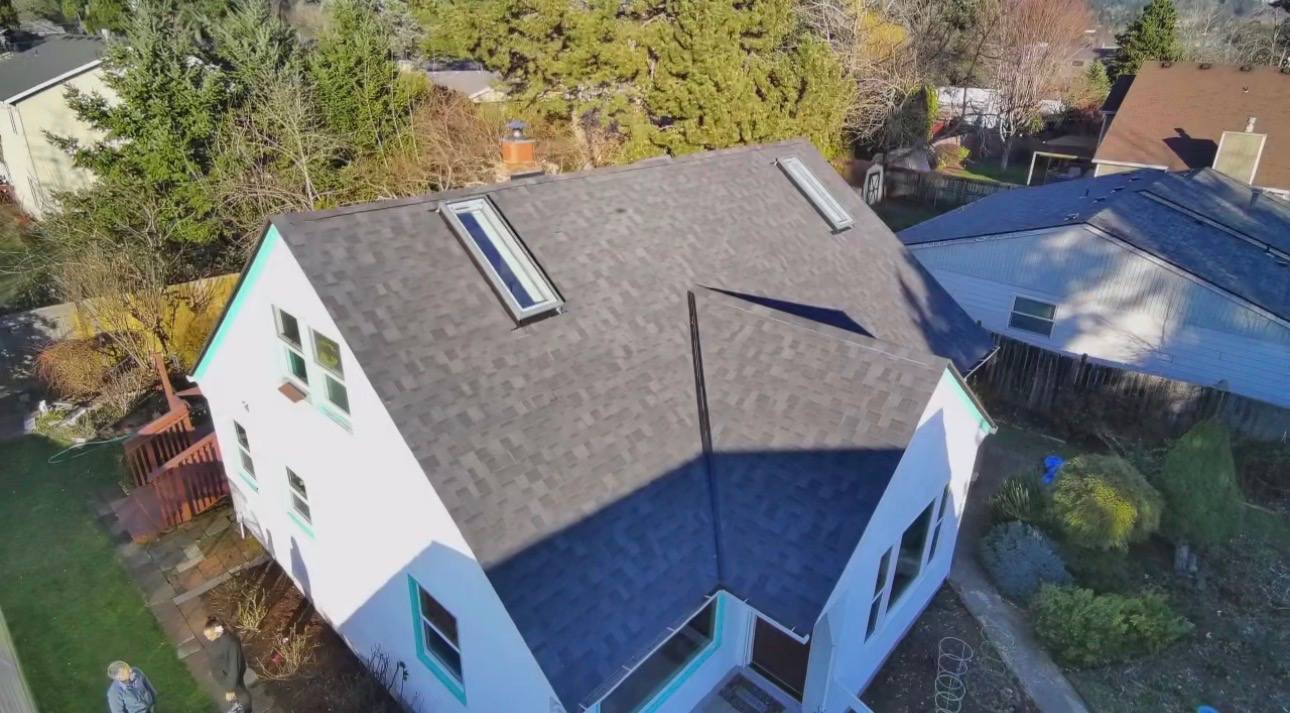 A finished roof with skylights on a white house, seen from above