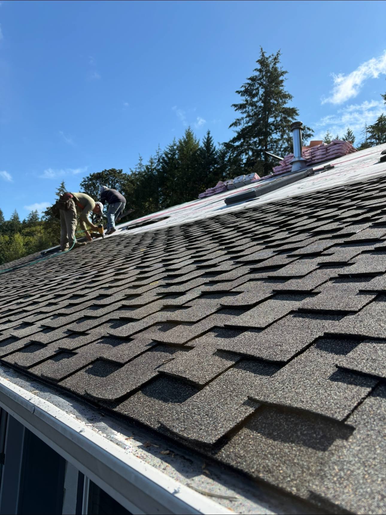 Close detail of new shingle courses against a blue sky