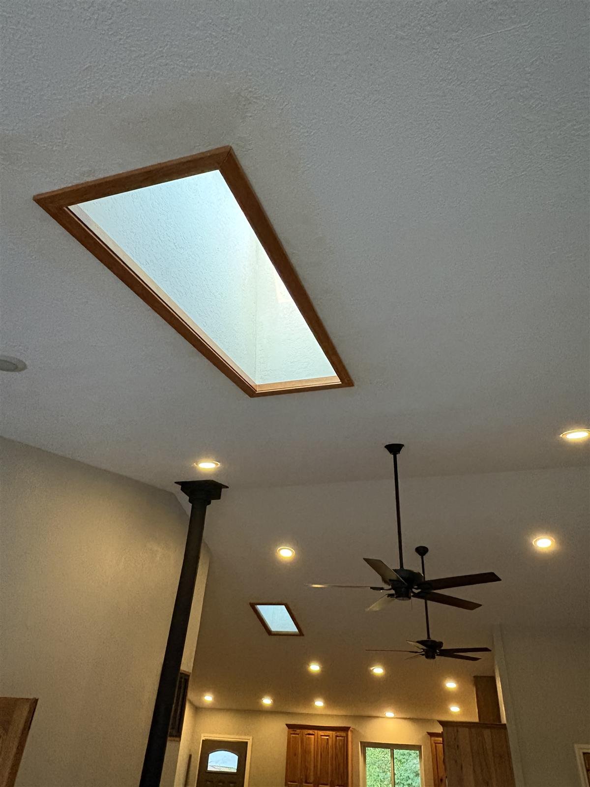 A wood framed skylight seen from inside, lighting a stairwell